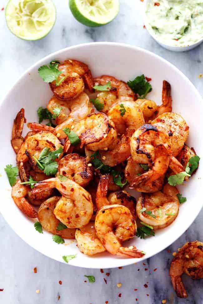 Grilled Spicy Lime Shrimp with Creamy Avocado Cilantro Sauce in a white bowl. 