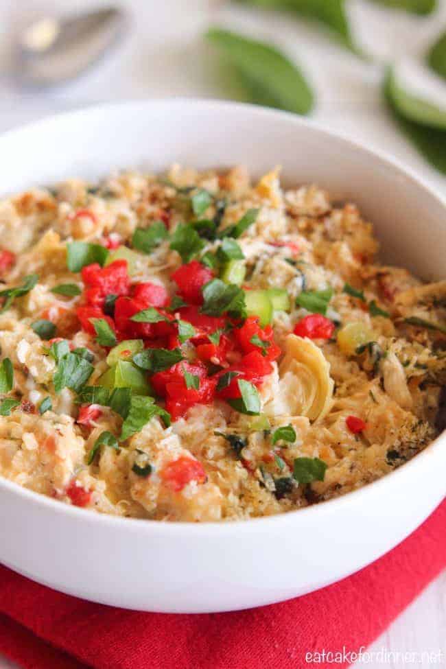 Close up of Creamy Spinach and Artichoke Chicken Quinoa in a white bowl. 