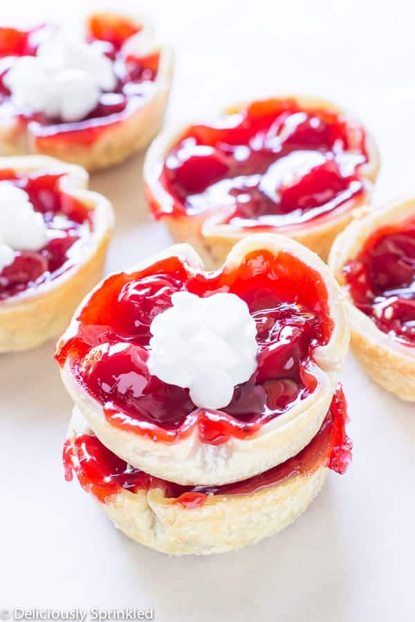 Mini Cherry Pies. Two are stacked on top of one another. 