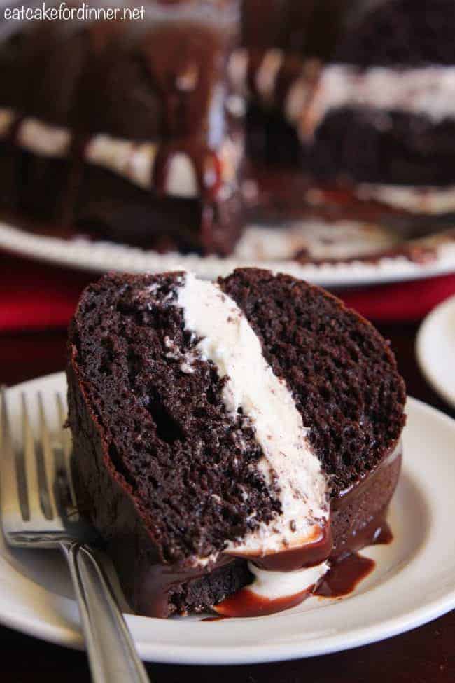 A slice of Chocolate Whoopie Pie Cake on a white plate with a metal fork. 