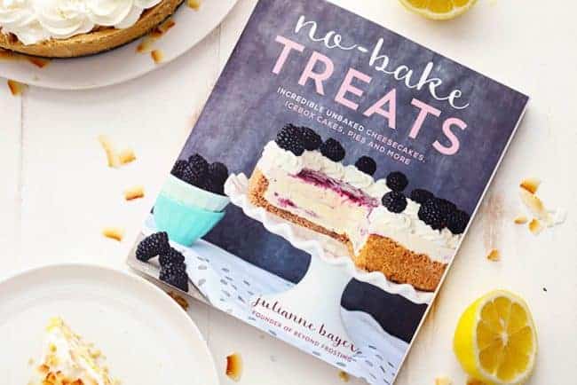 Cookbook named "No-Bake Treats" with a couple of white plates next to it.  