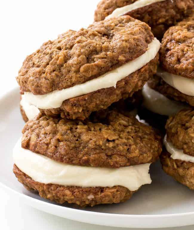 Homemade Oatmeal Cream Pies stacked on top of one another on a white plate. 