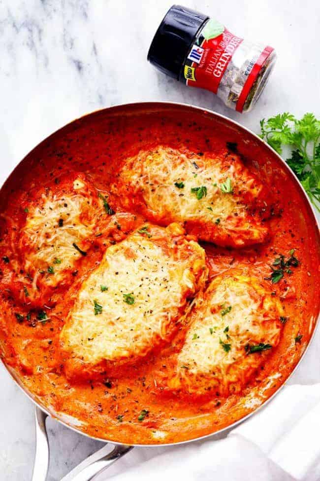 A McCormick Brand Italian Blend Grinder next to a pan of Creamy Tomato Italian Parmesan Chicken. 