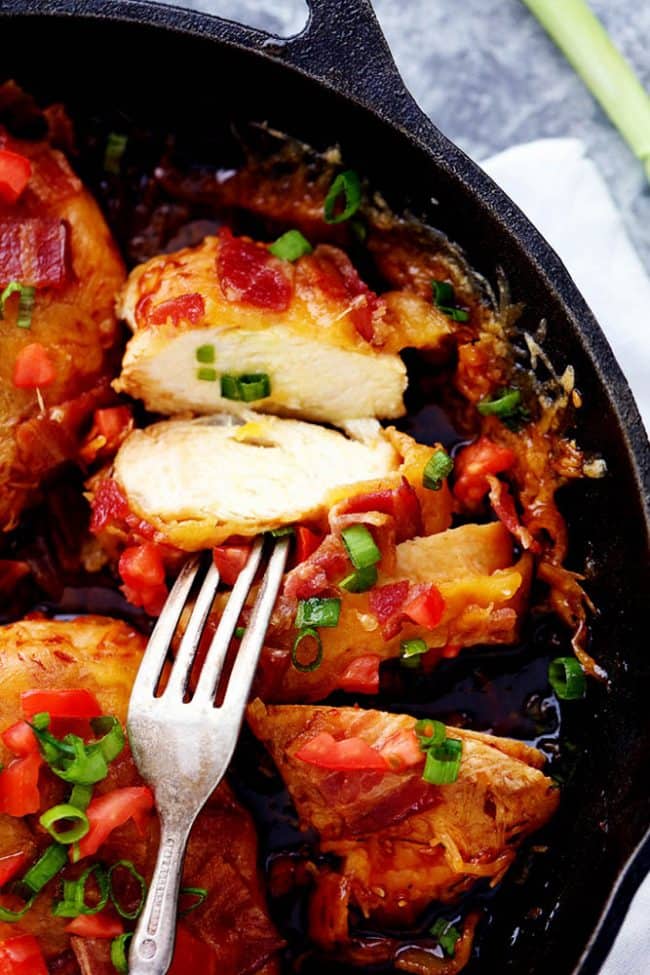 A sliced piece of Skillet Monterey Chicken in a black skillet. 