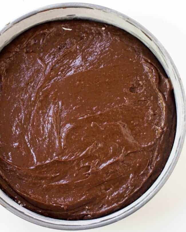 Uncooked brownies in a round cake pan. 