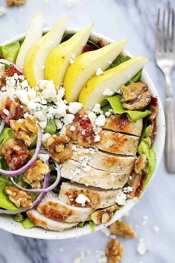 Grilled Chicken, Bacon, and Pear Salad with Poppyseed dressings in a white bowl. 