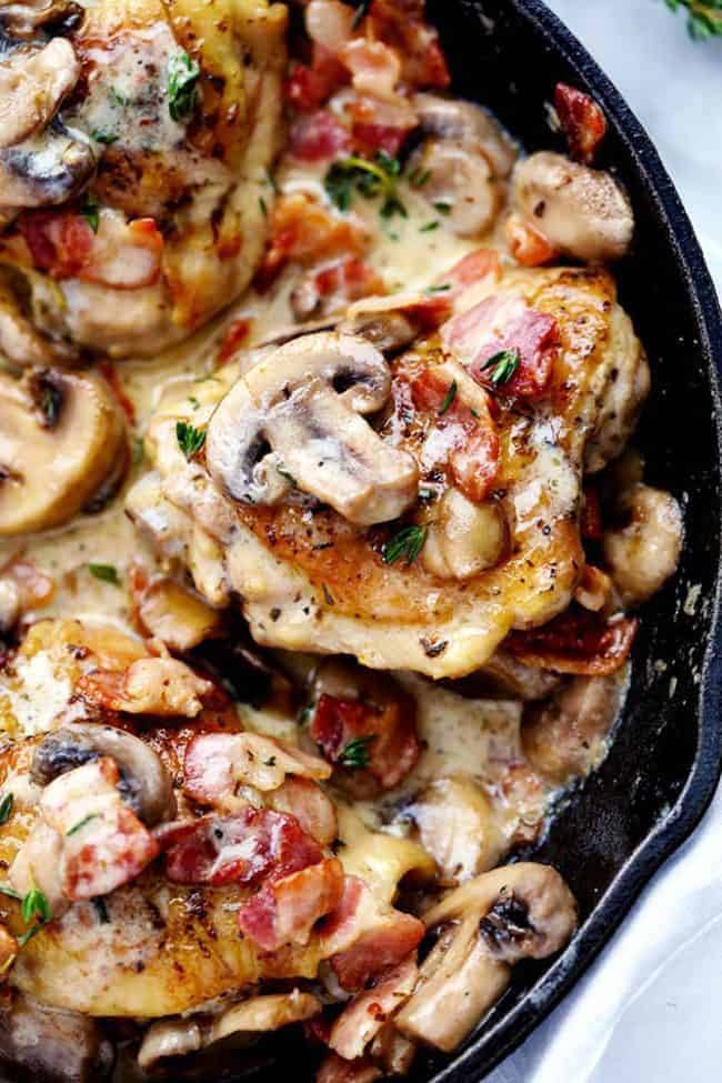 Close up of Creamy Bacon Mushroom Thyme Chicken in a black skillet. 