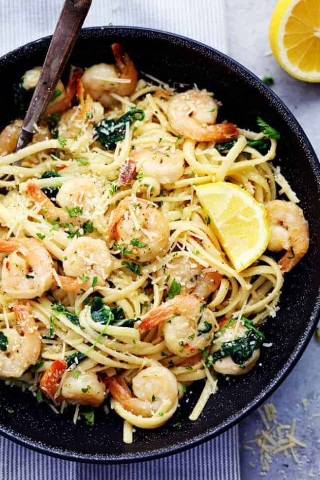 Lemon Garlic Parmesan Shrimp Pasta in a black bowl with a wooden spoon. 