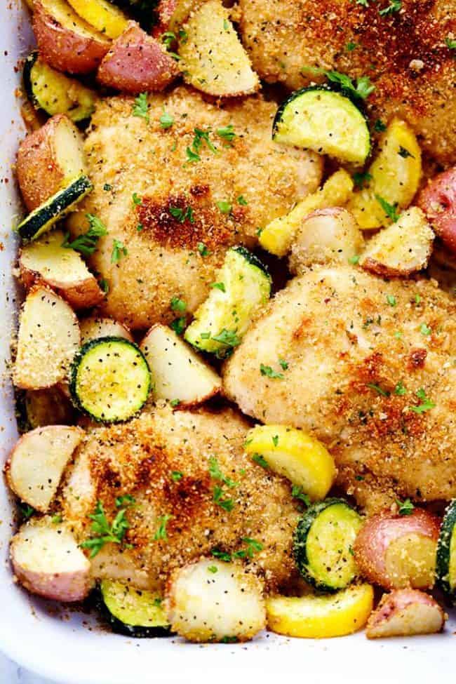 Close up of One Pan Crispy Parmesan Garlic Chicken with Vegetables in a white dish. 
