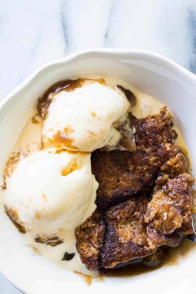 Snickerdoodle Cobbler with two scoops of vanilla ice cream over top in a white bowl. 