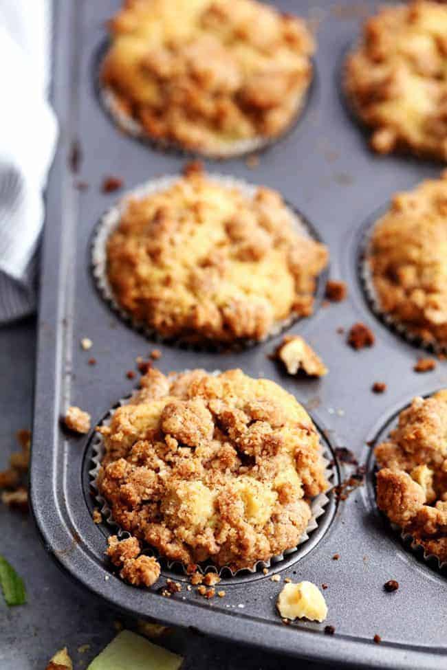 Apple cream cheese Crumb Muffins in a muffin tin.