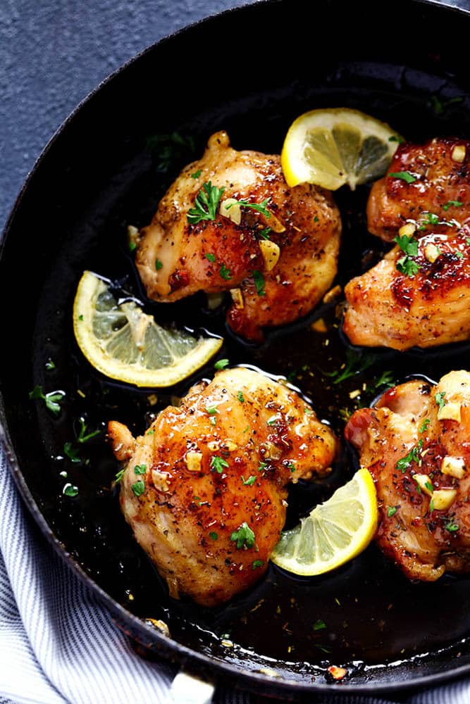 Glazed Lemon Honey Garlic Chicken on a black plate.