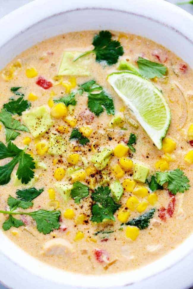 Mexican chicken corn chowder in a bowl with toppings on it. 