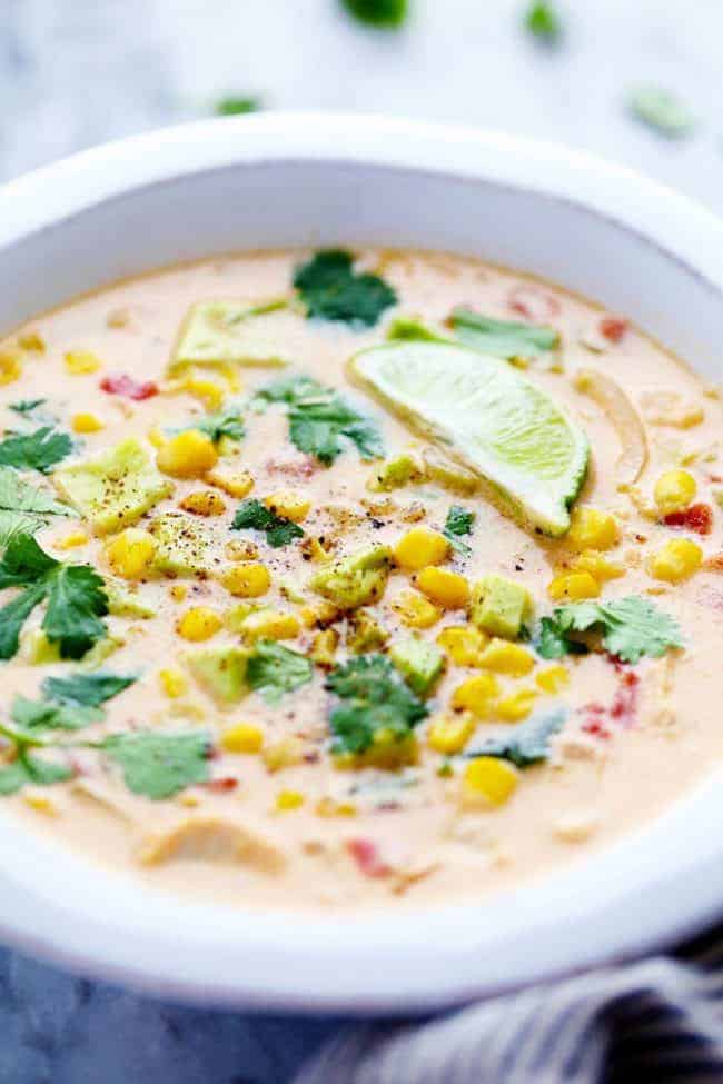 Mexican chicken corn chowder in a bowl with toppings on it. 