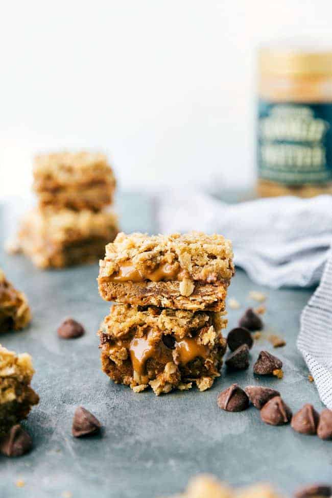 Biscoff oatmeal bar stacked on top of each other up with chocolate chips surrounding them on the table