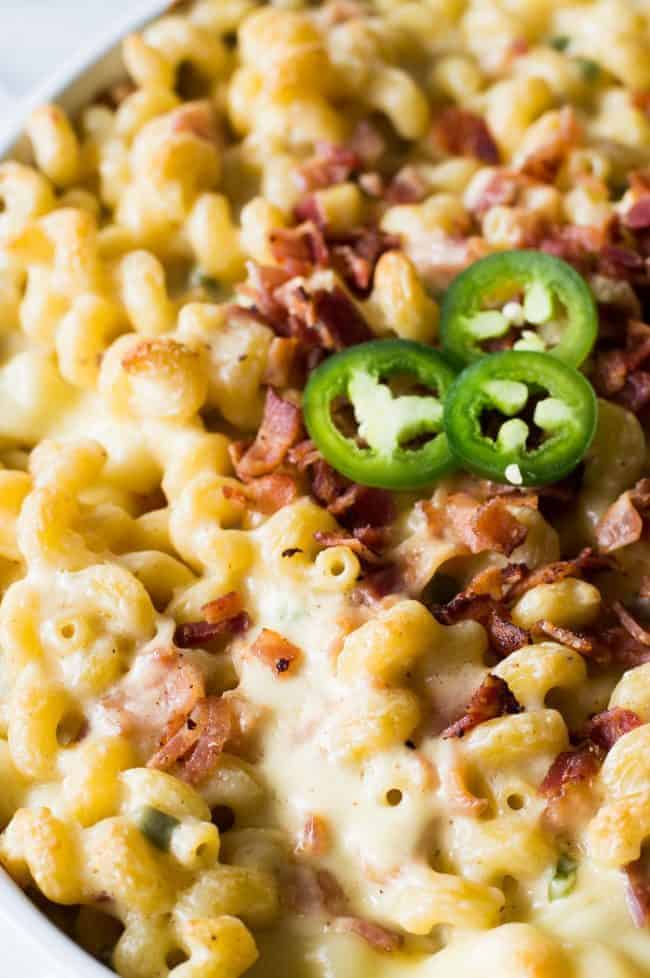 Jalapeño popper macaroni and cheese with jalapeños garnished on top with bacon. 