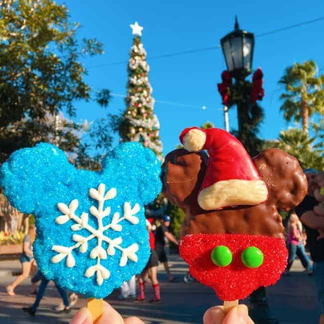 A photo with two Christmas Mickey Mouse ice cream bars. One is blue with a snowflake on itSpace and the other looks like a Santa Claus with a Santa hat, red frosting and two green buttons for the pants