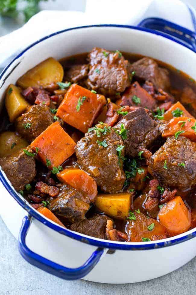 Beef stew with bacon and a large pot.