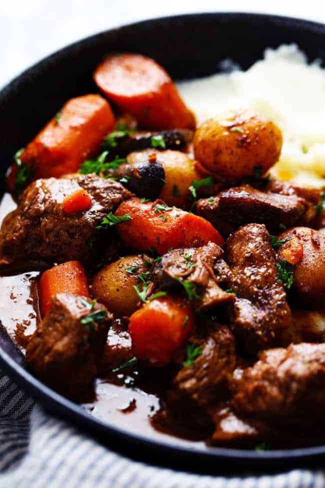 slow Cooker Beef Bourguignon with mashed potatoes on a plate up close photo 