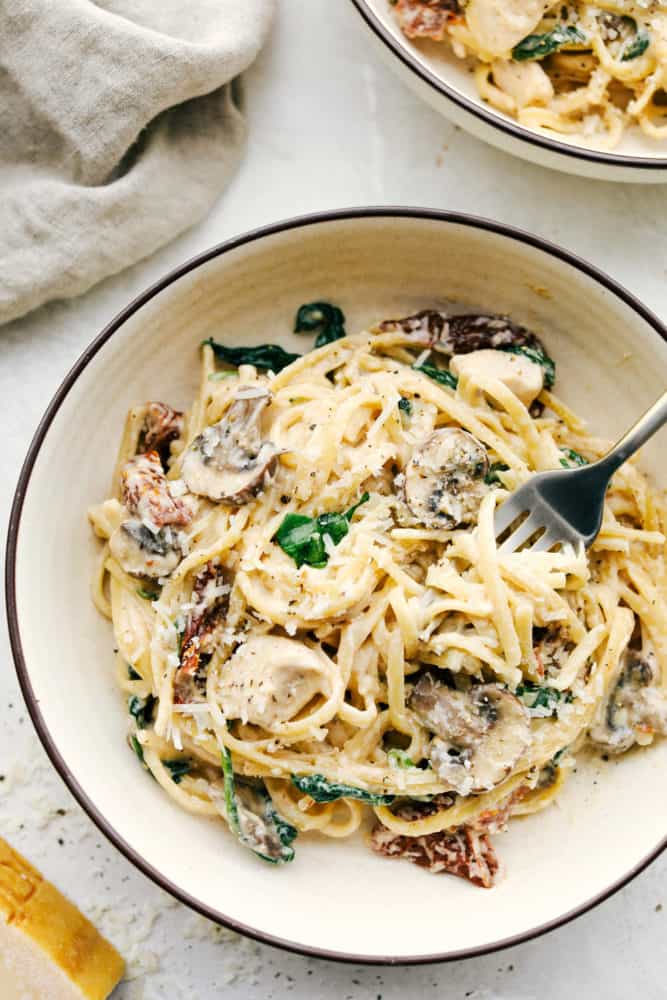 One pot creamy chicken mushroom Florentine in a bowl with a fork in it. 