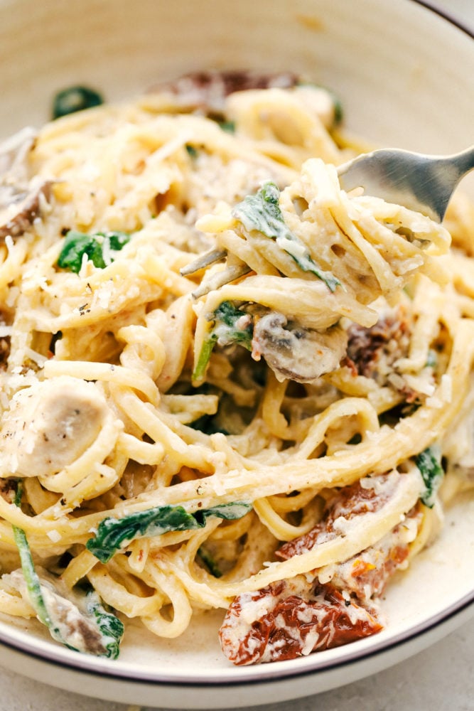 A bowl full of chicken mushroom Florentine with a fork. 