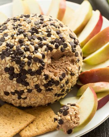This Snickers Cheese Ball is perfect for holiday potlucks and gatherings! Loaded with caramel, chocolate and peanut butter, it's perfect served with apple slices, other fruit, and graham crackers.
