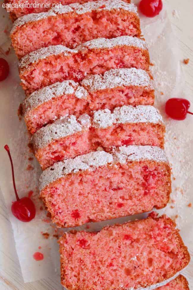Cherry Almond Bread sliced into pieces with cherries on the side. 