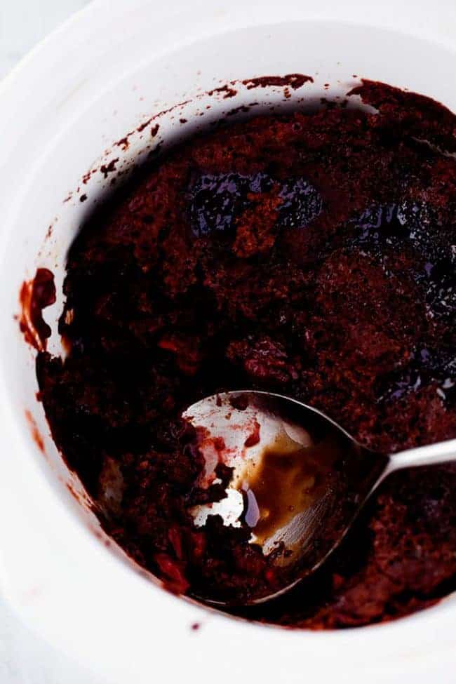  Cherry chocolate hot fudge cake in the slow cooker with a silver spoon dishing it out.