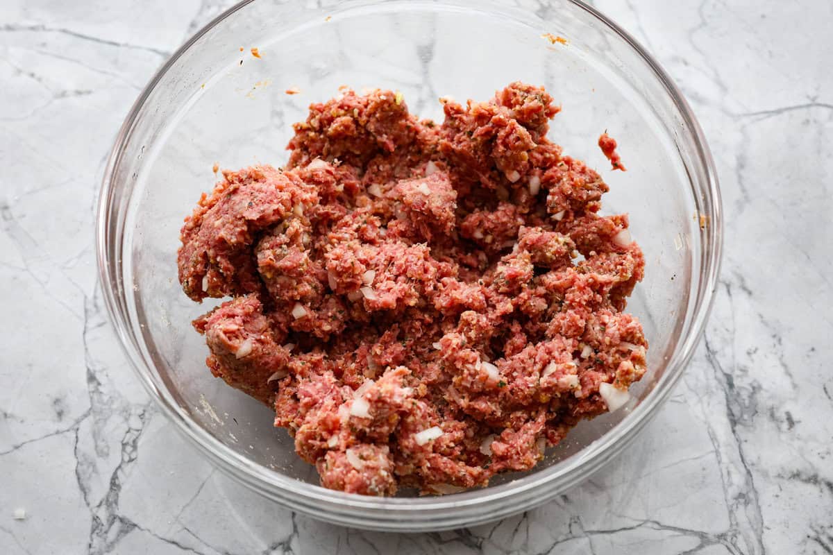 Mozzarella Stuffed Meatballs take classic meatballs to the next level! Tender and juicy with melty cheese on the inside. Serve these meatballs as a party appetizer or over spaghetti noodles for a hearty meal! Second photo of the meatball mixture mixed in a bowl.