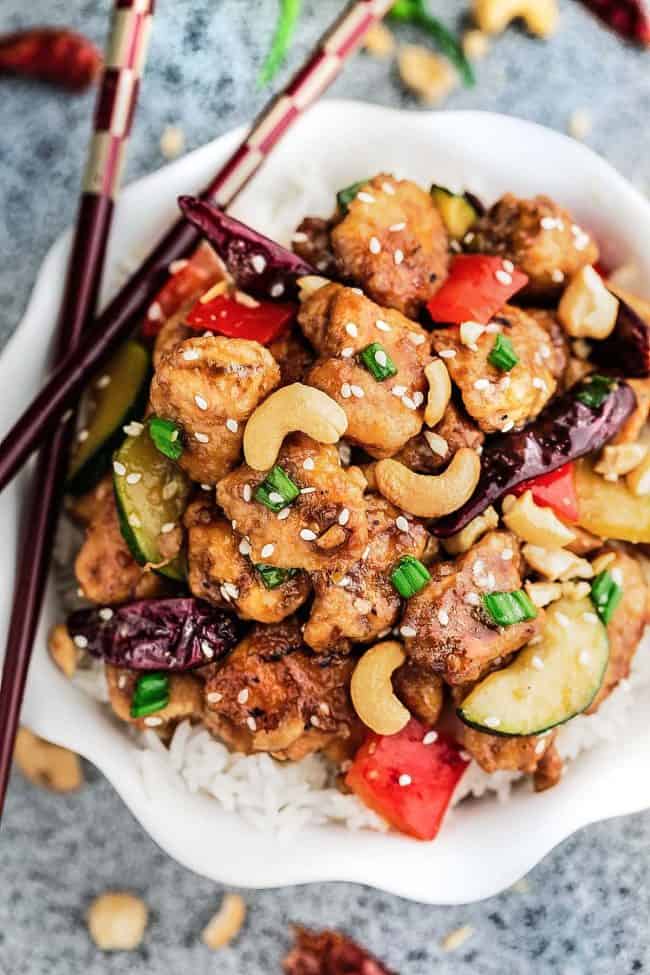 Skinny Slow Cooker Kung Pao Chicken in a bowl with rice and chopsticks to the side. 