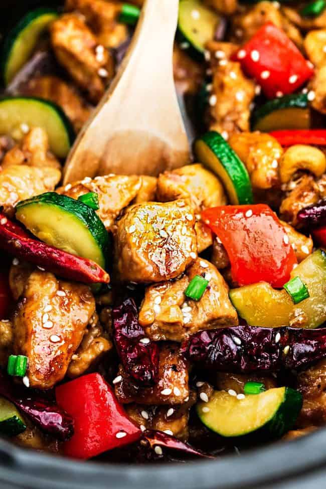Skinny Slow Cooker Kung Pao Chicken unclose photo with a wooden spoon. 