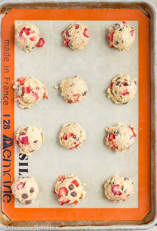Strawberry Chocolate Chip Cookie dough in rows on a tray.