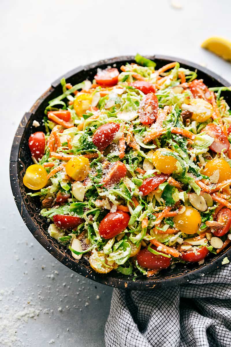 A simple brussels sprouts parmesan salad in a black bowl.