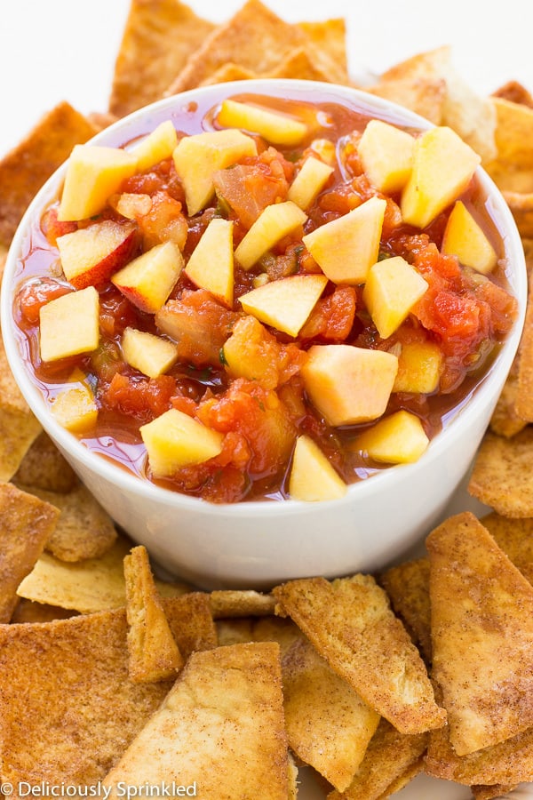 Fresh Fruit Salsa in a white bowl surrounded by fruit.