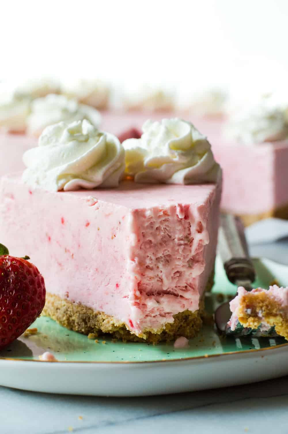 Kein Gefrorener Erdbeer-Joghurt-Kuchen auf einem grünen Teller backen.