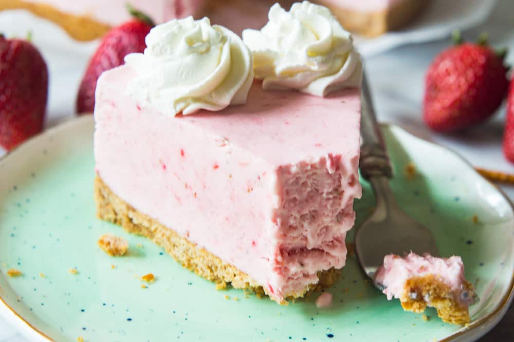 No Bake Frozen Strawberry Yogurt Pie! This frozen pie is perfect for warmer weather! No baking needed, and the pie itself is a creamy cool strawberry and cream flavor. Made with greek yogurt, real cream, and fresh strawberry puree! All on top of a pretzel crust. 