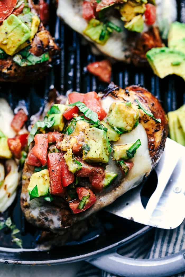 Grilled California Avocado Chicken being picked up off a skillet with a spatula.