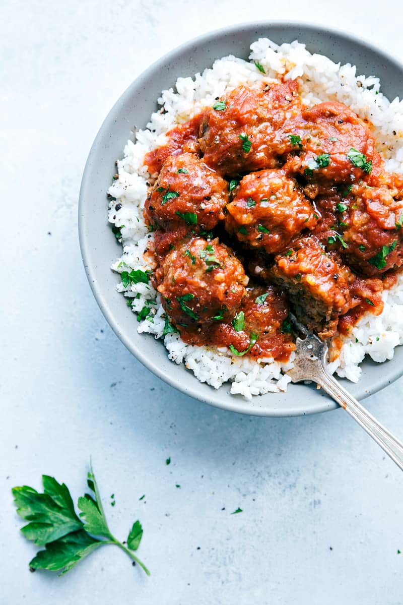 Slow Cooker Porcupine Meatballs on rice in a gray bowl.