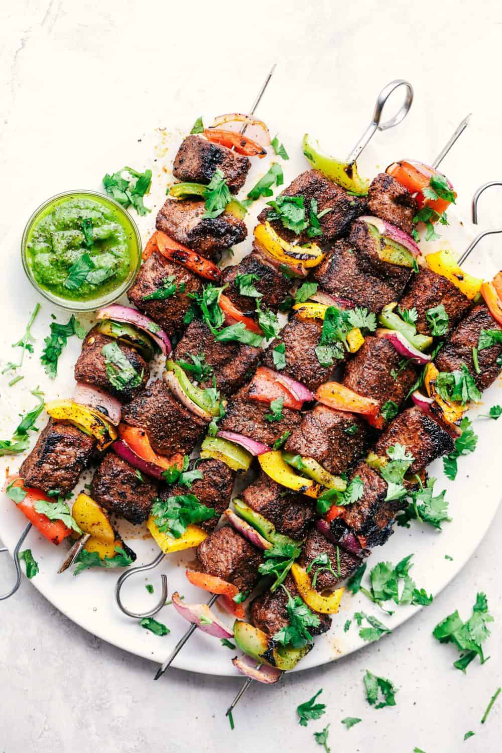 Finished Grilled Steak Fajita Skewers with Avocado Chimichurri on a plate.