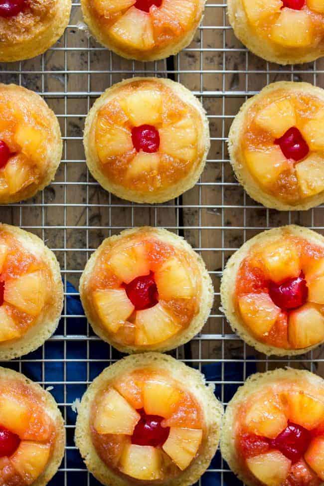 Easy, from-scratch, pineapple upside-down cupcakes on a cooling rack in rows.