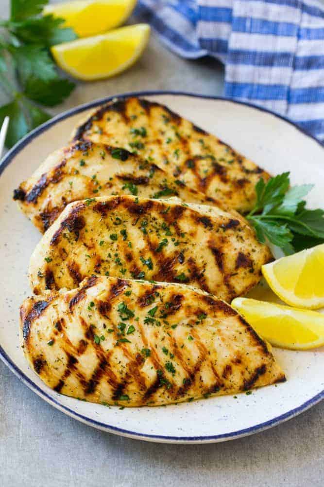 Grilled citrus and herb chicken on a white plate.