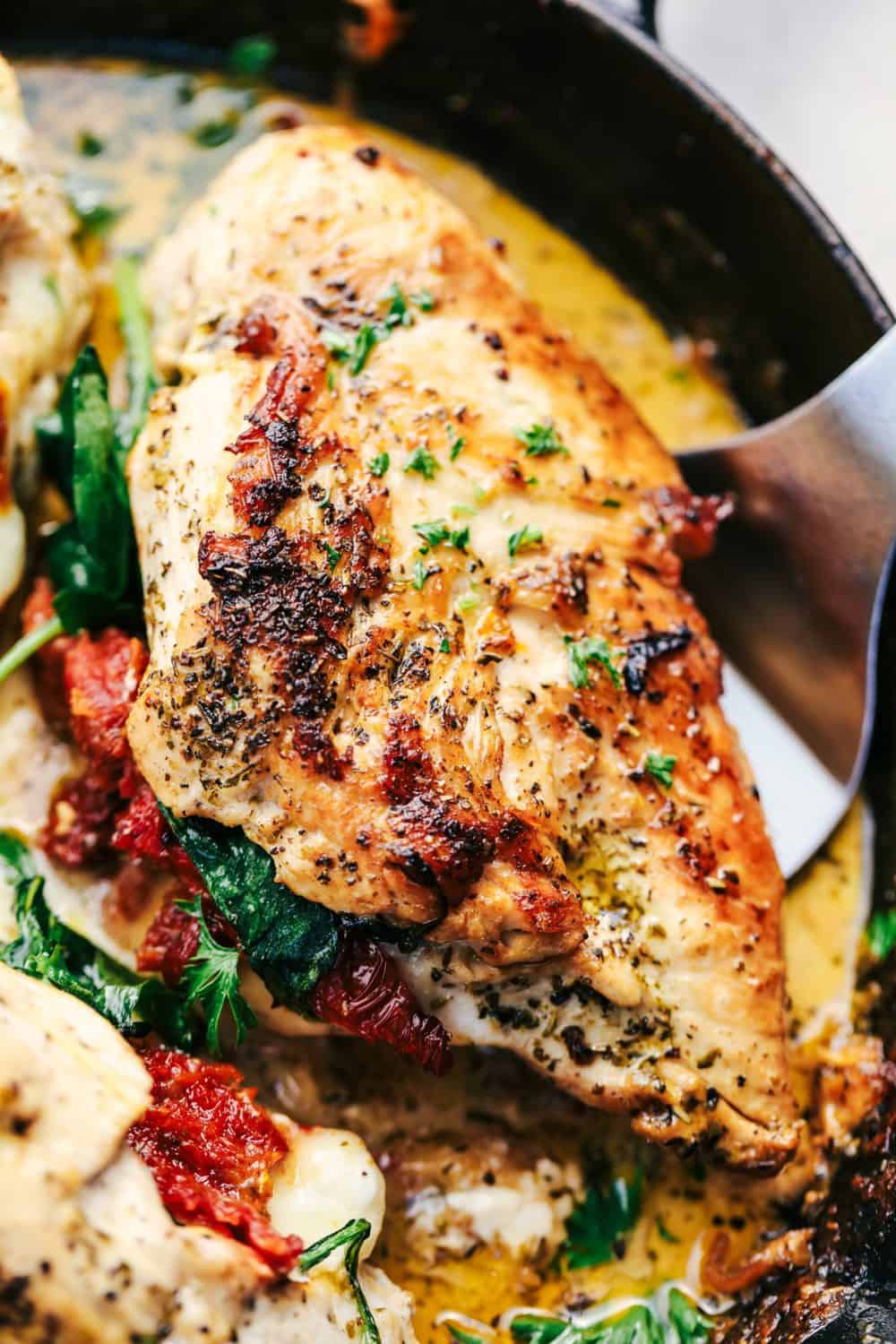 Close up of Tuscan Garlic Chicken being scooped out of a pan