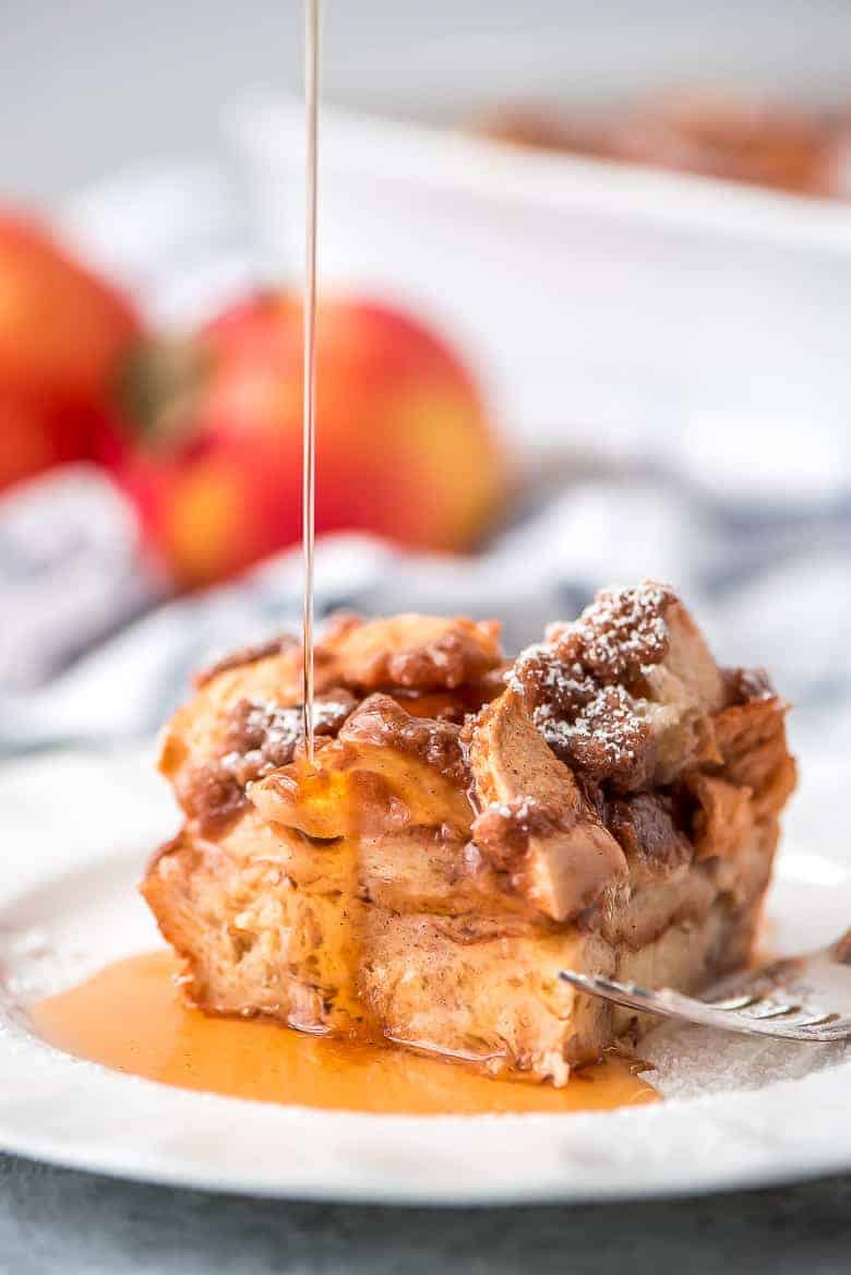 Overnight Cinnamon Apple French Toast Casserole with syrup being drizzled over it.