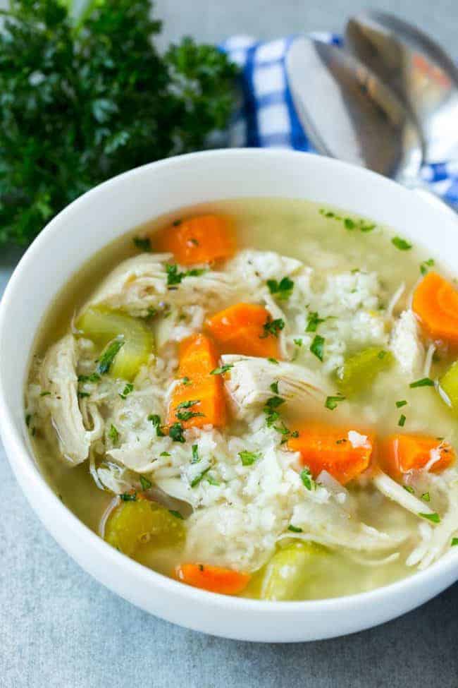 This slow cooker chicken and rice soup in a white bowl.
