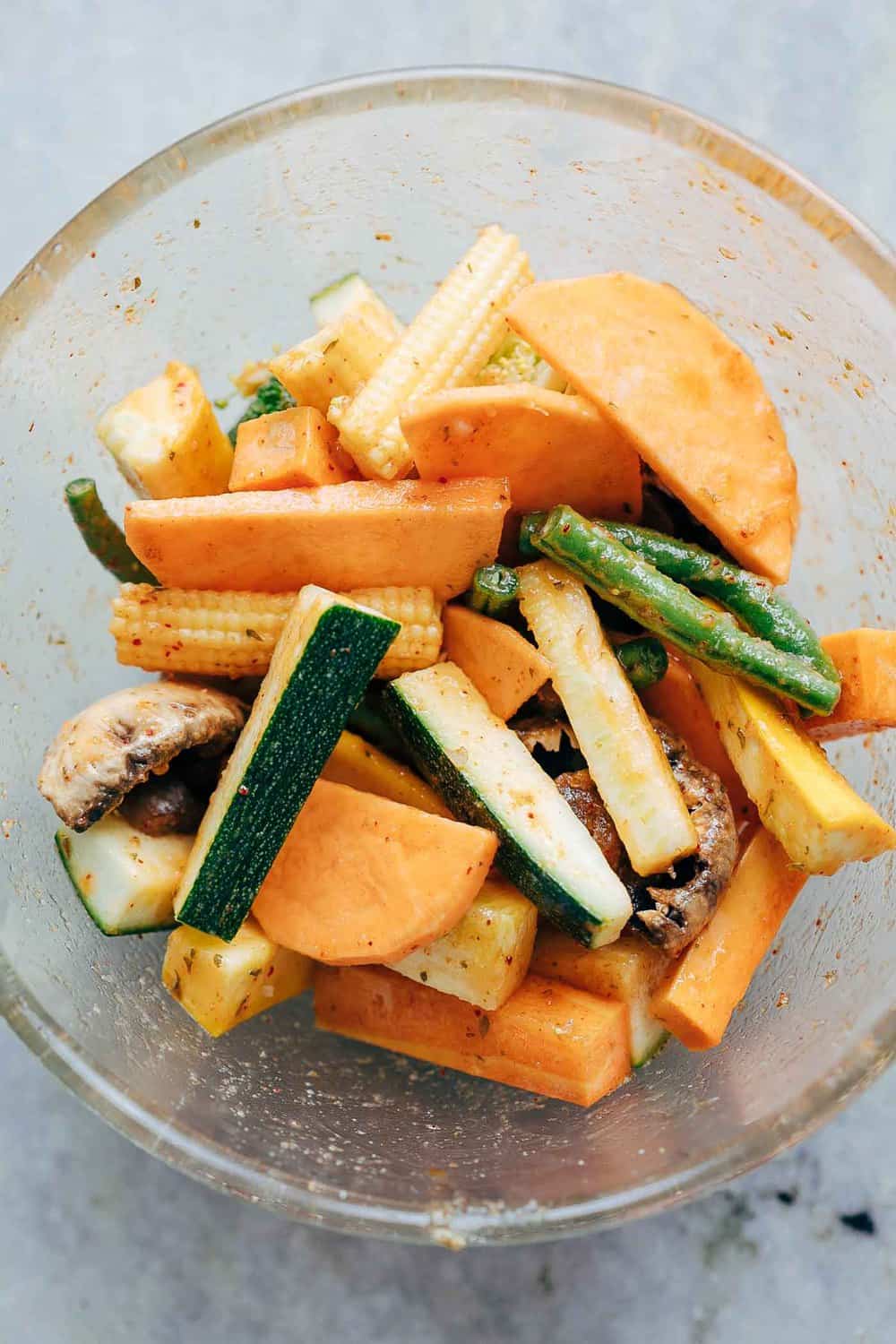 Veggies stacked and seasoned in a bowl.