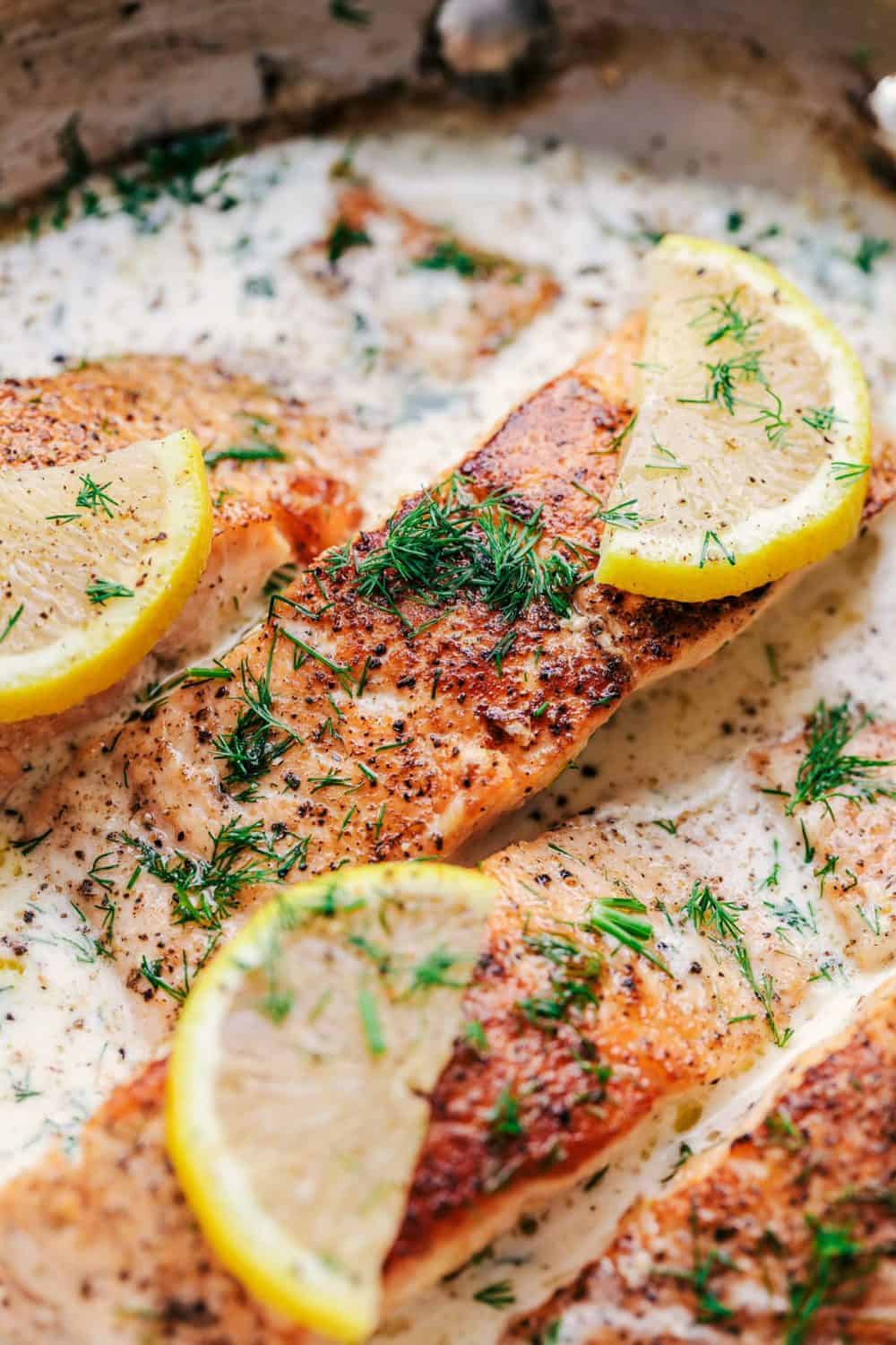 Pan Seared Salmon with a Creamy Lemon Dill Sauce in a skillet.