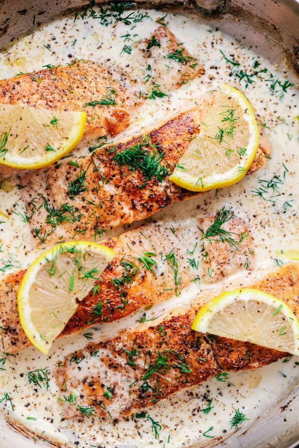 Pan Seared Salmon with a Creamy Lemon Dill Sauce in a skillet.