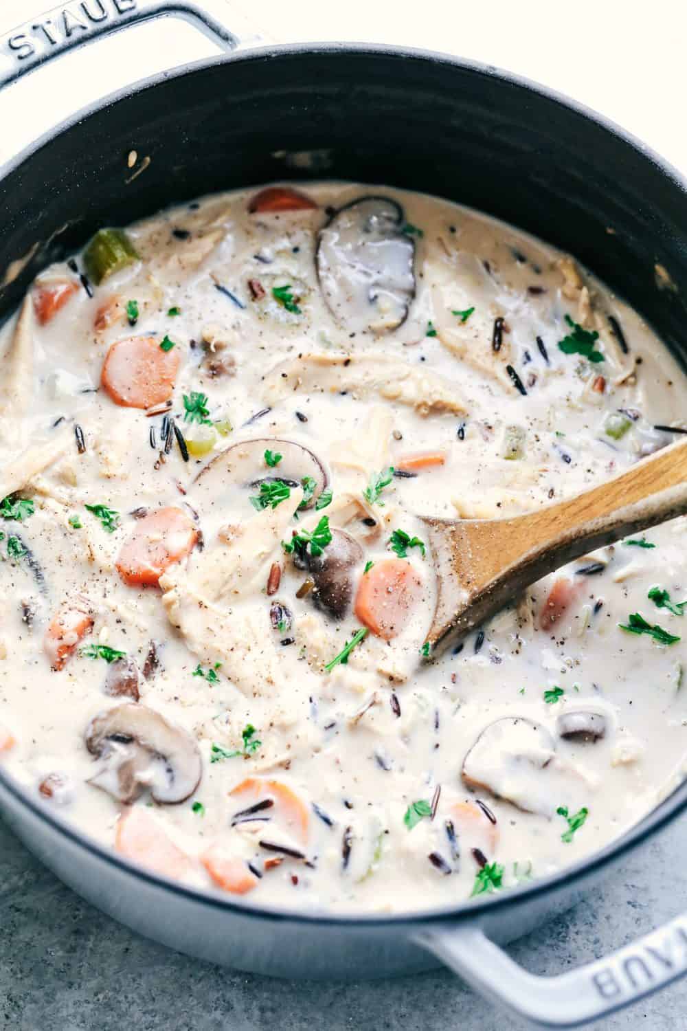 Creamy Turkey Wild Rice Soup in a large pot with a wooden spoon.