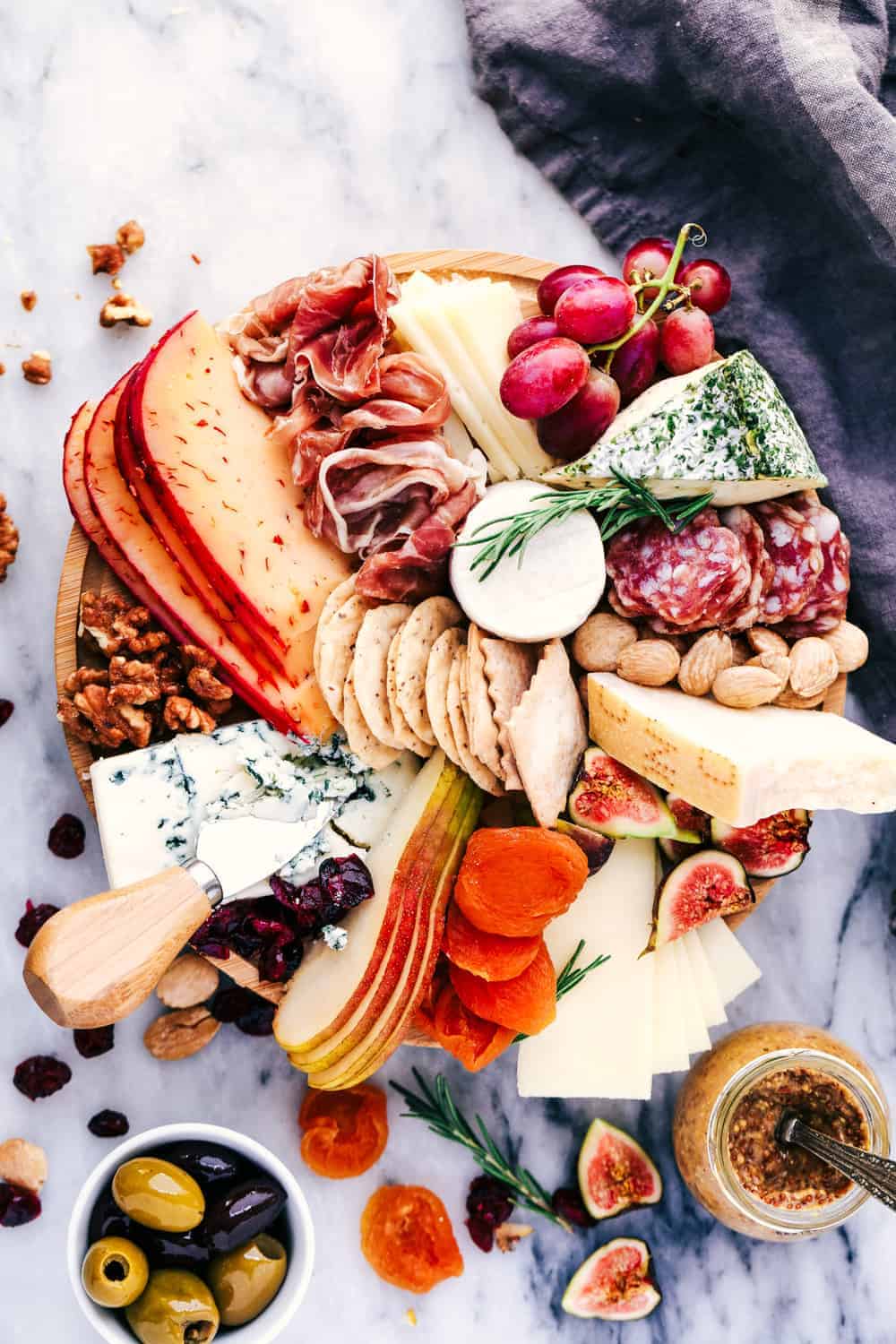 Cheese Board filled with meats, cheeses, nuts, and fruit.