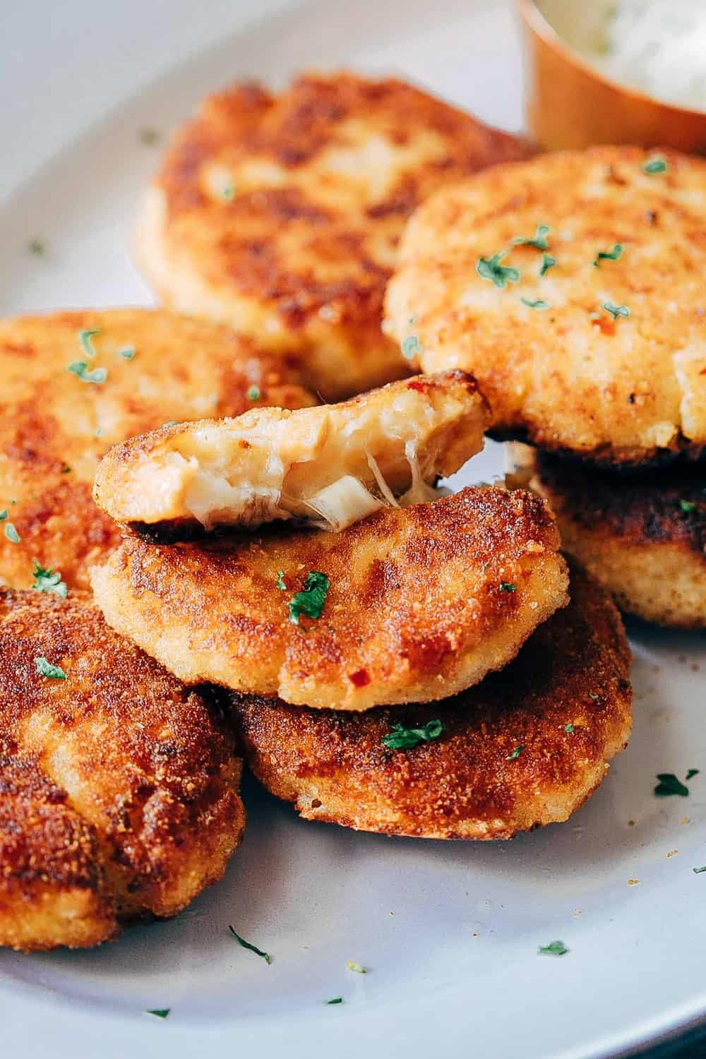 Stretchy cheesy shot of ham mashed potato cakes to show texture